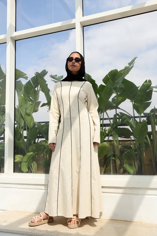 "An effortless beige linen bohemian dress, designed for seamless day-to-night transitions."فستان كتان "بوهو" باللون البيج، مثالي لجميع المناسبات.