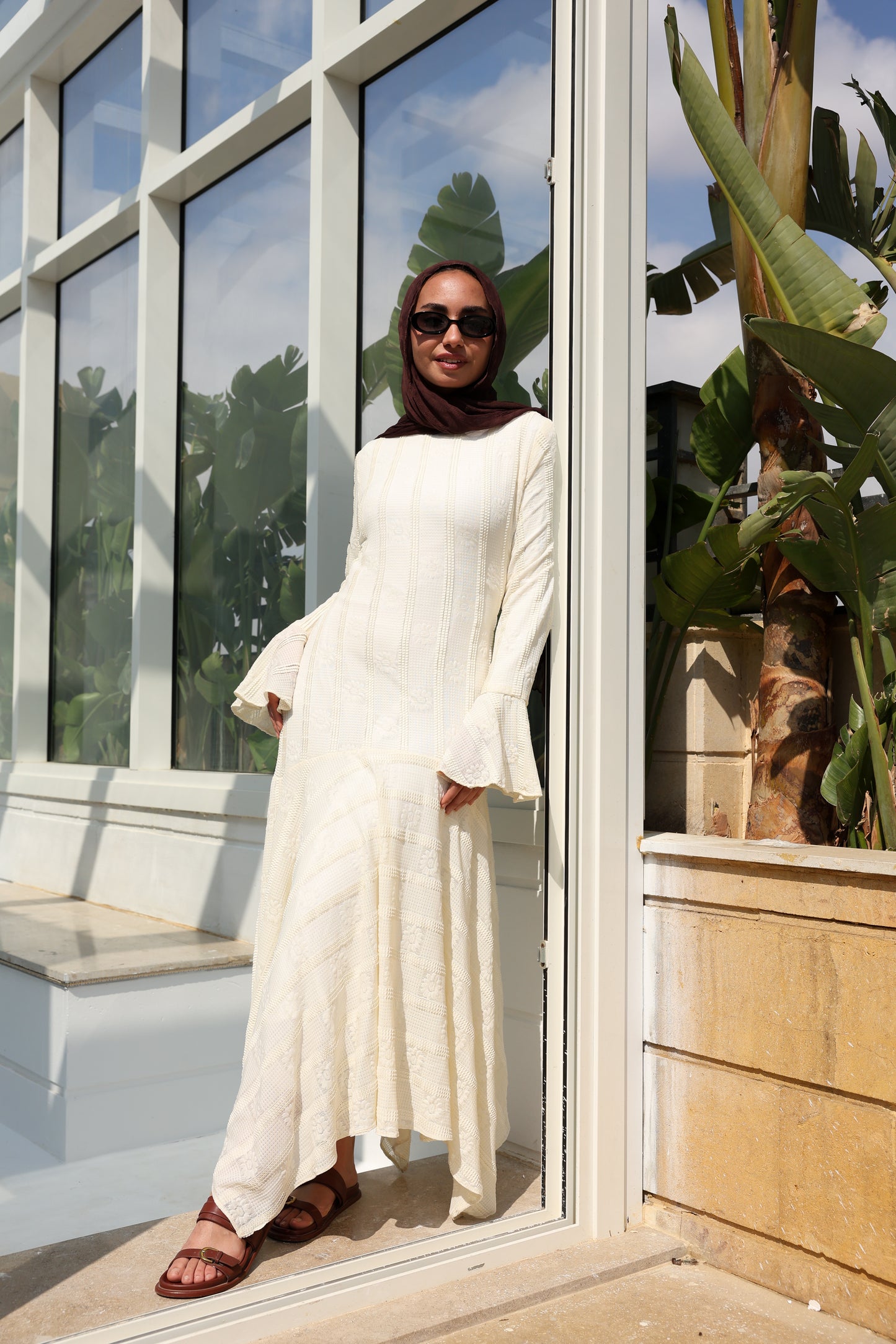 lace dress with a unique design in brown , fully lined." فستان من الدانتيل الفاخرباللون الكريم، يجسد براعة التصميم بتفاصيل فريدة وبطانة كامله ناعمة تمنحكِ رقياً لا يضاهى."