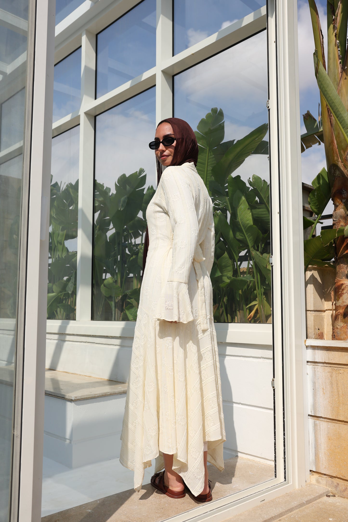 lace dress with a unique design in brown , fully lined." فستان من الدانتيل الفاخرباللون الكريم، يجسد براعة التصميم بتفاصيل فريدة وبطانة كامله ناعمة تمنحكِ رقياً لا يضاهى."