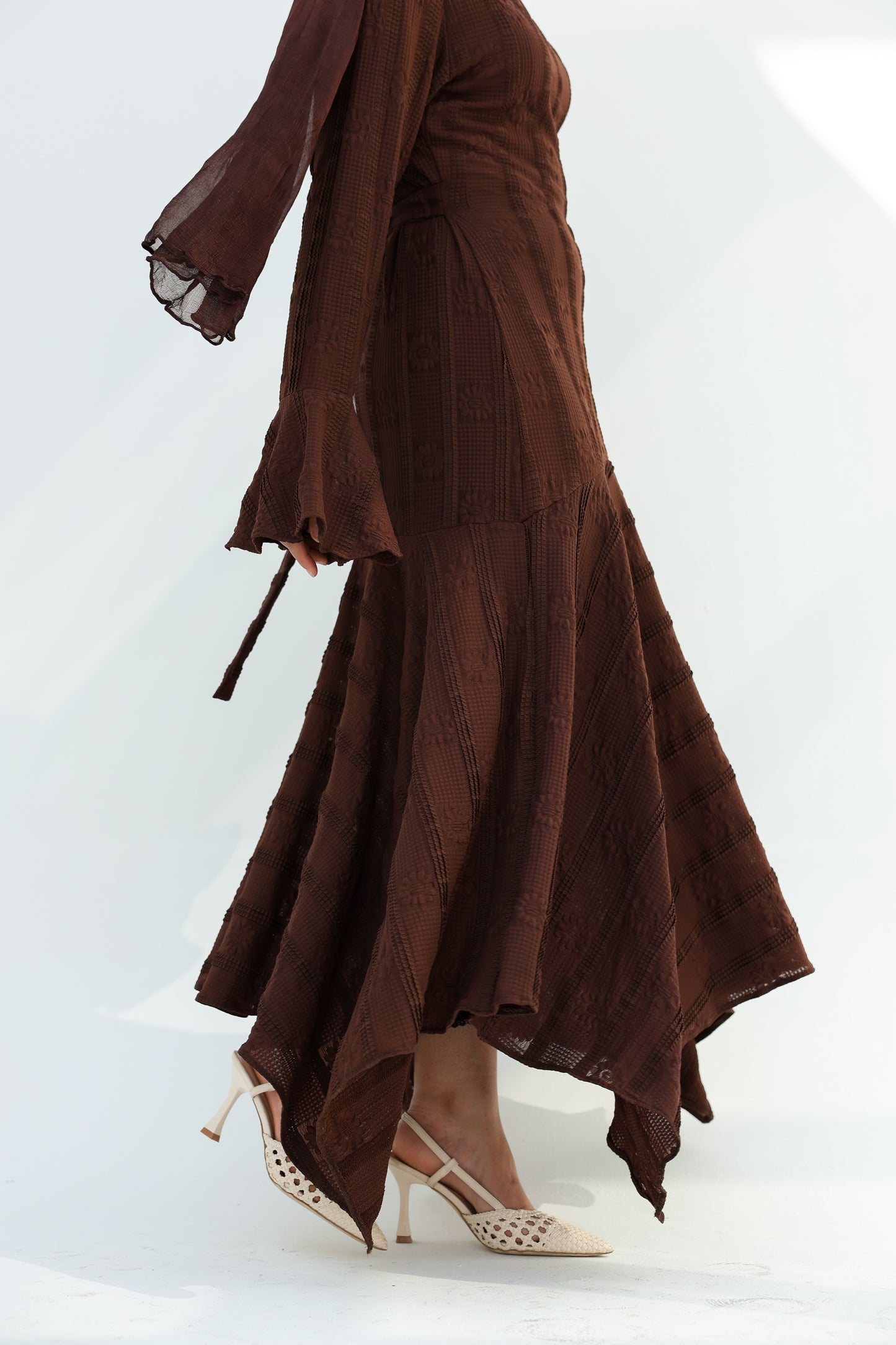 lace dress with a unique design in brown , fully lined." فستان من الدانتيل الفاخرباللون البني، يجسد براعة التصميم بتفاصيل فريدة وبطانة كامله ناعمة تمنحكِ رقياً لا يضاهى."