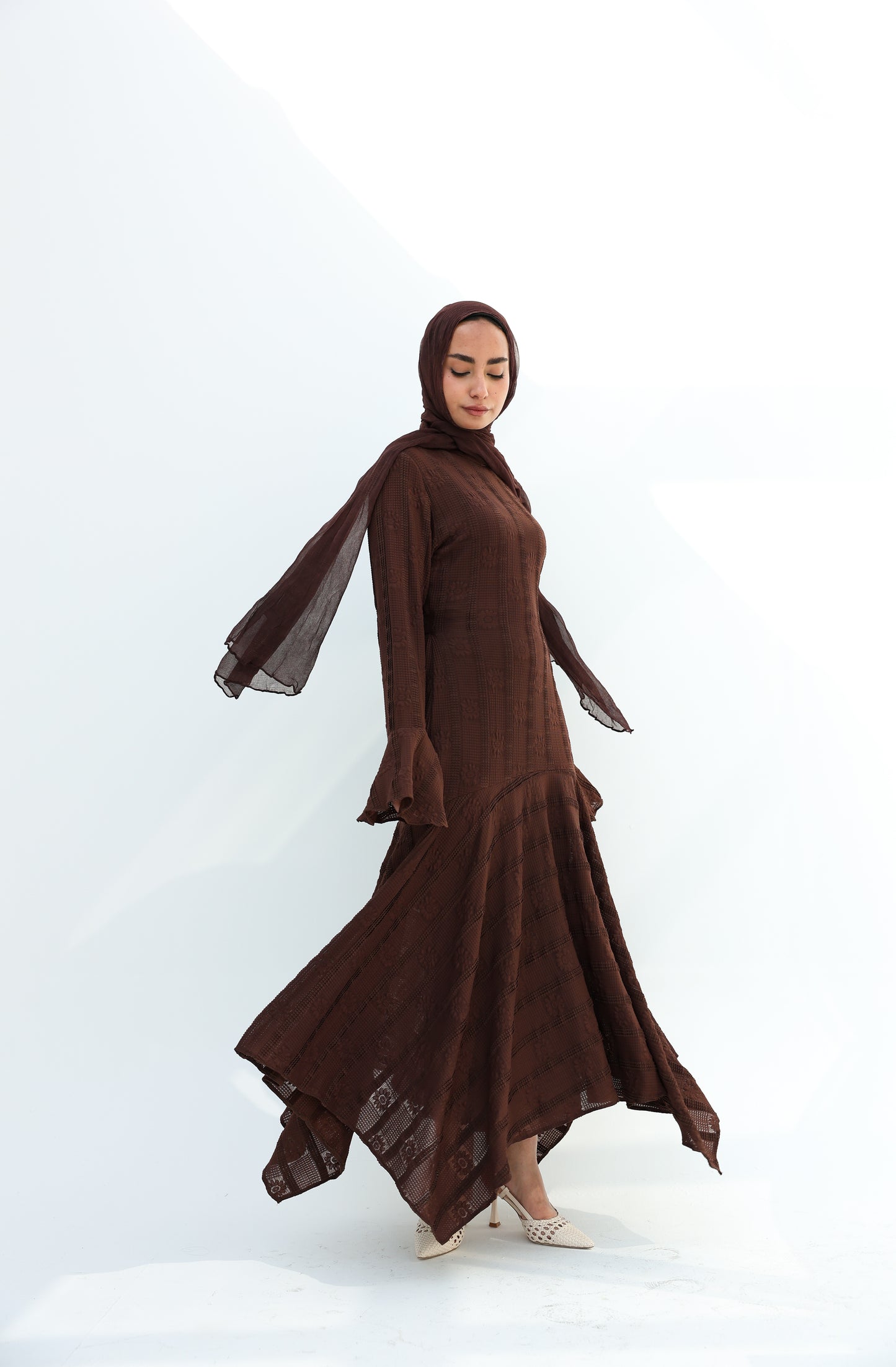 lace dress with a unique design in brown , fully lined." فستان من الدانتيل الفاخرباللون البني، يجسد براعة التصميم بتفاصيل فريدة وبطانة كامله ناعمة تمنحكِ رقياً لا يضاهى."