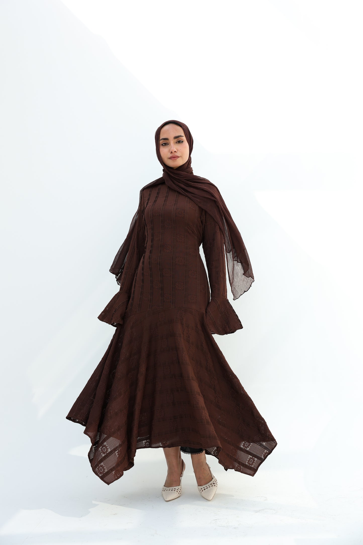 lace dress with a unique design in brown , fully lined." فستان من الدانتيل الفاخرباللون البني، يجسد براعة التصميم بتفاصيل فريدة وبطانة كامله ناعمة تمنحكِ رقياً لا يضاهى."