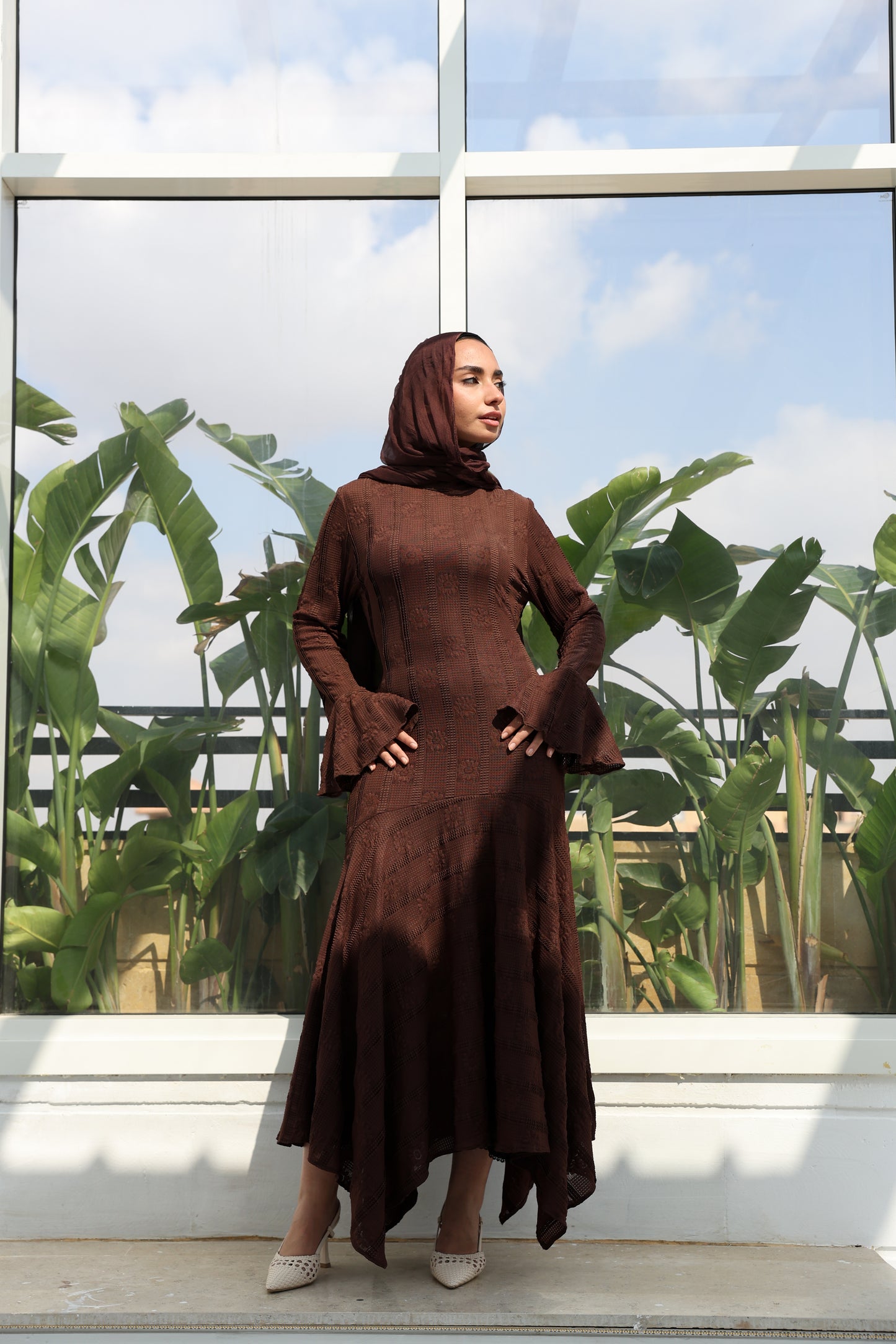 lace dress with a unique design in brown , fully lined." فستان من الدانتيل الفاخرباللون البني، يجسد براعة التصميم بتفاصيل فريدة وبطانة كامله ناعمة تمنحكِ رقياً لا يضاهى."