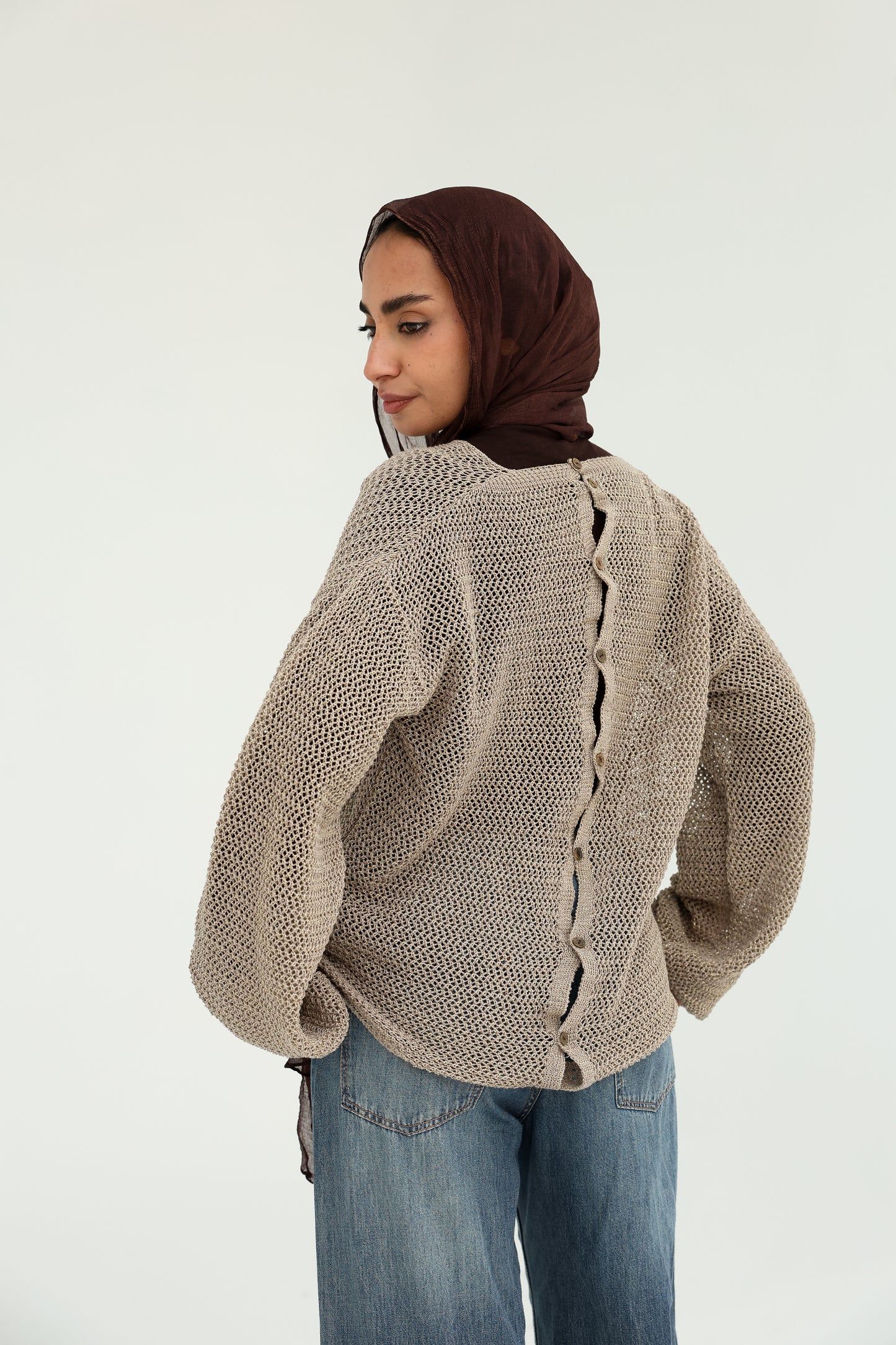 Convoluted shimmered knitted top with bottoms back   بلوزة تريكو لامع بتصميم متداخل مع قطعة بظهر مرصع بالزراير