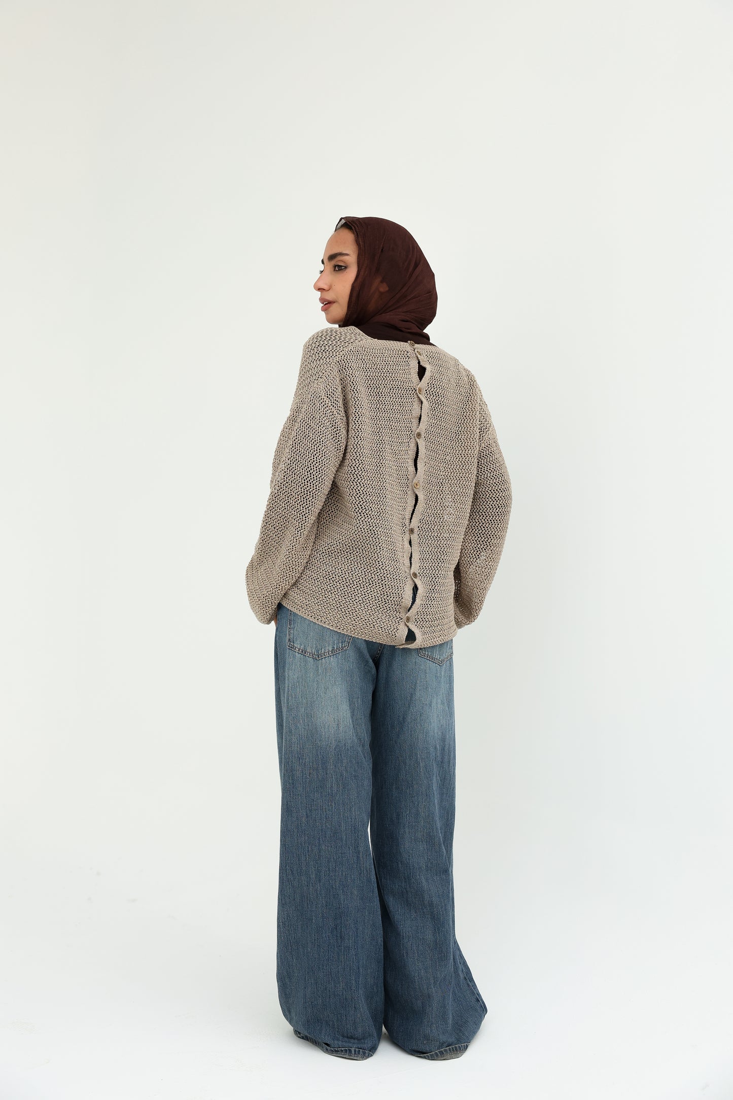 Convoluted shimmered knitted top with bottoms back   بلوزة تريكو لامع بتصميم متداخل مع قطعة بظهر مرصع بالزراير