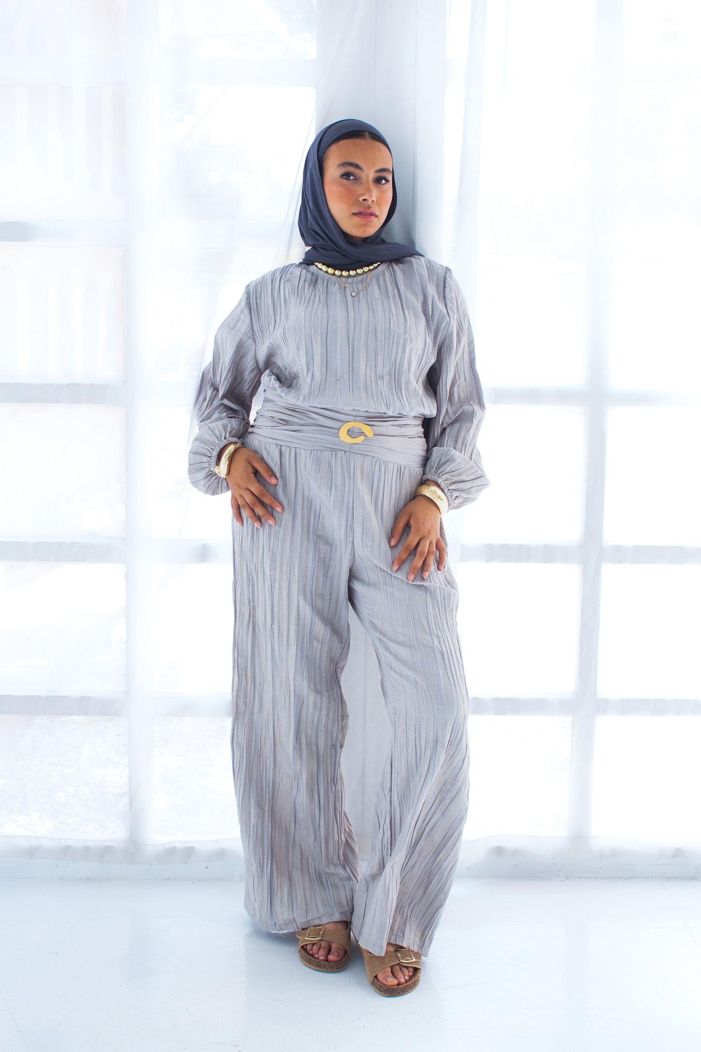 Shimmered crashed cotton jumpsuit in gray with golden brooch