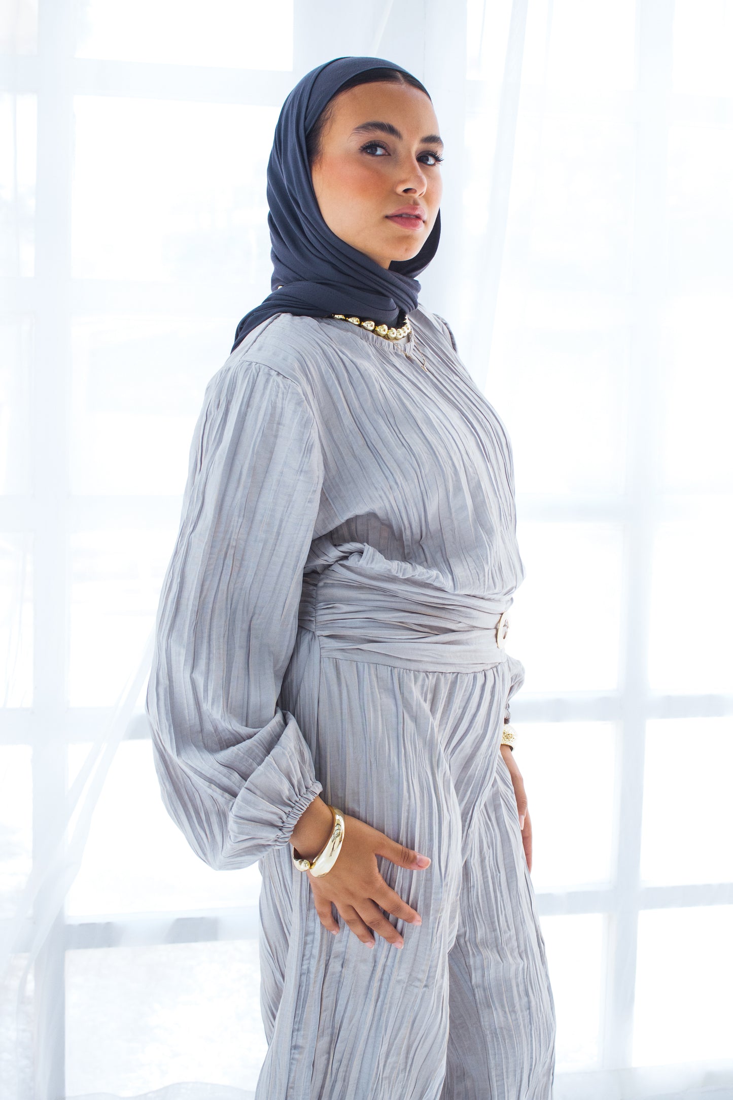 Shimmered crashed cotton jumpsuit in gray with golden brooch