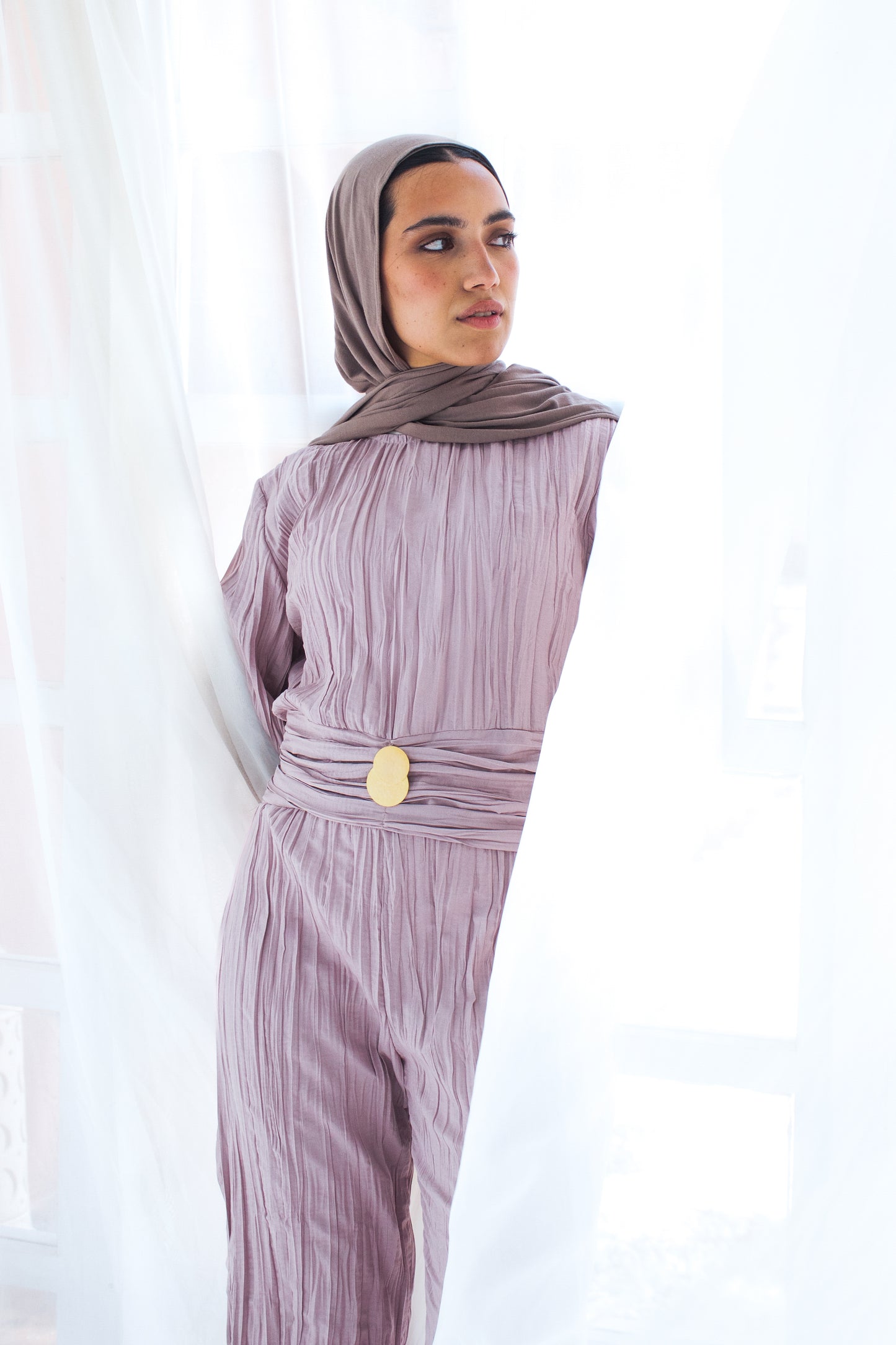Shimmered crashed cotton jumpsuit in light mauve with golden brooch
