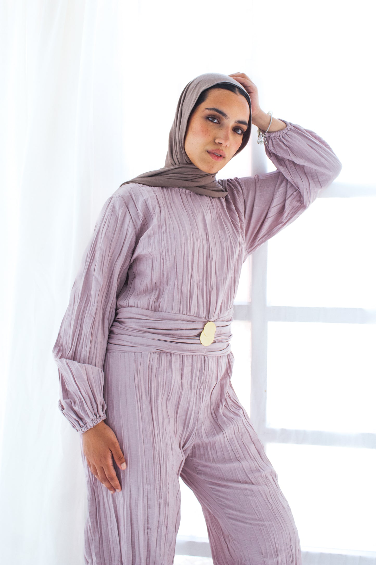 Shimmered crashed cotton jumpsuit in light mauve with golden brooch